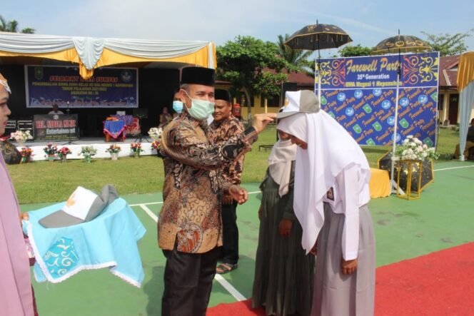 
FOTO : Kepala SMA Negeri 1 Kepenuhan M. Ardi SS M.Pd melepaskan atribut siswa/i, dalam rangka pengembalian siswa ke orang tua, Kamis (19/5/2022)