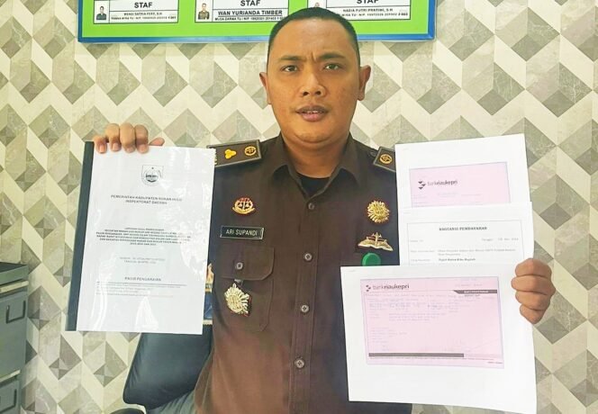 
FOTO : Kasi Intel Kejari Rohul Ari Supandi, SH MH memperlihtakan  bukti setoran pengembalian & setoran pajak kurang bayar di Disdikpora Rohul, Selasa 31/5/2022)  