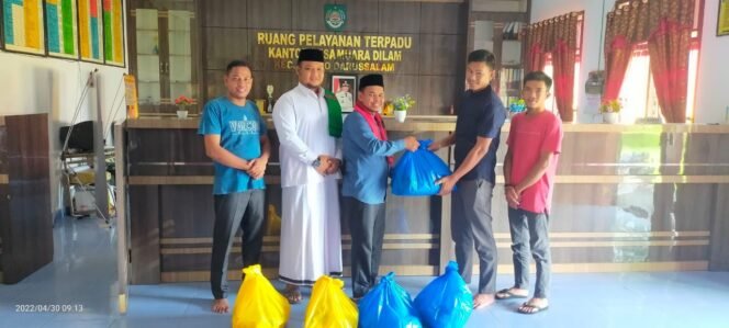 
FOTO : Kades Muara Dilam Zulfikar SHi membagikan ratusan paket sembako untuk warga kurang mampu. (lsc)