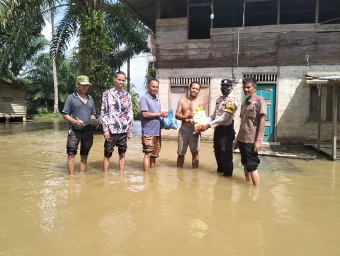 
Desa RBS Dilanda Banjir, Sekdes dan Personil Polsek Kepenuhan Salurkan Bantuan