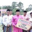 FOTO : Bupati Rohul H. Sukiman didampingi Kalaksa BPBD Rohul Zuljandri Rosa S.Si MM menyerahkan Bantuan Bencana Angin Puting Beliung, Rambah Hilir, Jumat (9/12/2022)