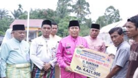 FOTO : Bupati Rohul H. Sukiman didampingi Kalaksa BPBD Rohul Zuljandri Rosa S.Si MM menyerahkan Bantuan Bencana Angin Puting Beliung, Rambah Hilir, Jumat (9/12/2022)